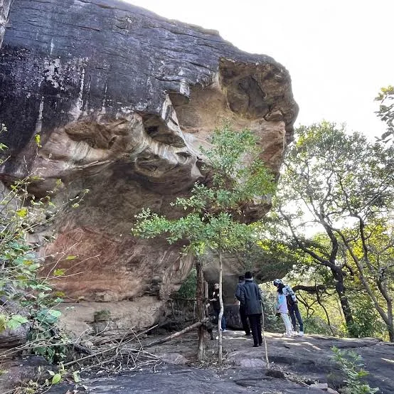 Visitors viewing prehistoric rock painting shelters at Bhimbetka near Ratapani Tiger Reserve